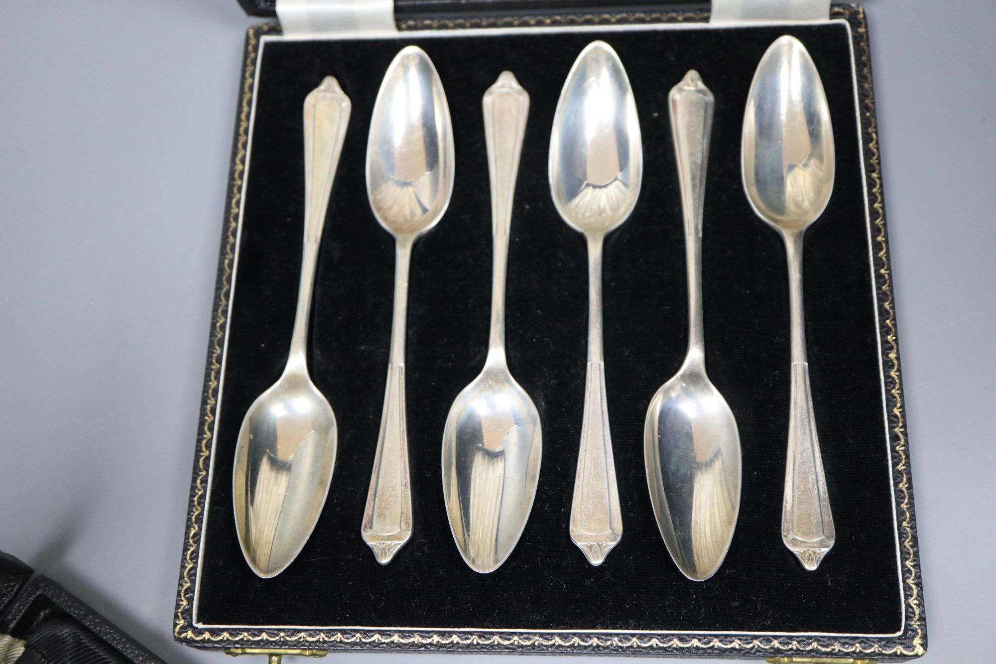 A 1930s cased set of six bean end silver coffee spoons and a later set of six silver grapefruit spoons.